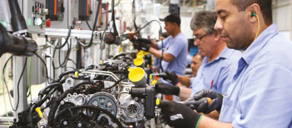 Empregados montando motores na linha de produção